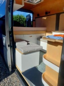 Intérieur aménagé d’un van avec banquettes et rangements