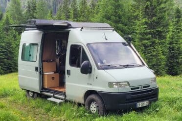 Kastenwagen auf Waldlichtung geparkt