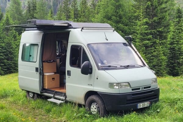 Fourgon aménagé stationné en clairière forestière