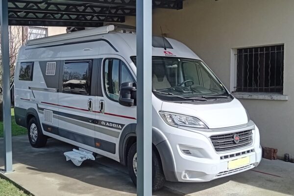 Camping-car blanc stationné sous un abri