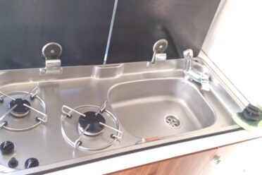 Piccolo angolo cottura con lavello e piano cottura a gas in acciaio inox