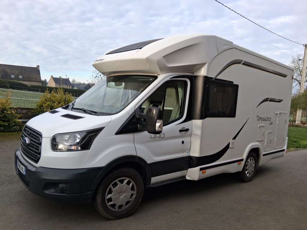 Camping-car blanc stationné sur route rurale