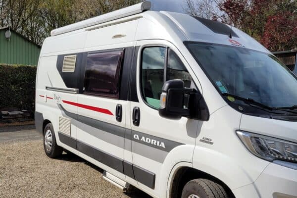 Camping-car Adria Twin blanc garé sur gravier