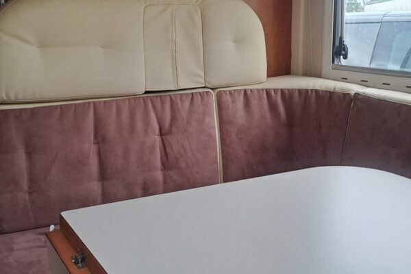 Coin repas d'un camping-car avec banquettes et table