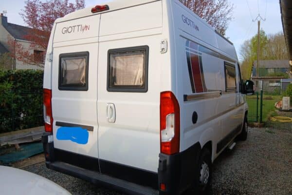 Camping-car blanc Giottiline stationné dans une cour