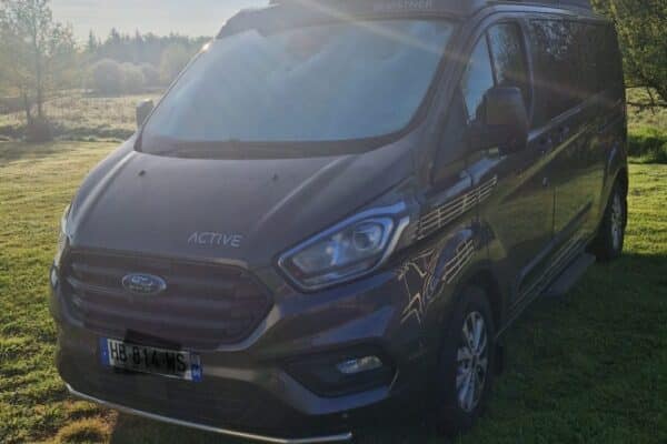 Van aménagé avec toit relevable au lever du soleil