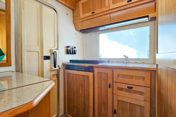 Cuisine aménagée de camping-car avec rangements en bois