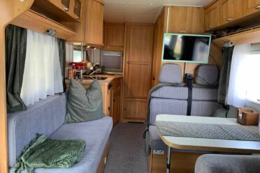 Innenansicht von Wohnmobil mit Küche und Wohnzimmer