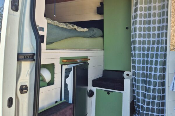 Intérieur aménagé de van avec lit et kitchenette