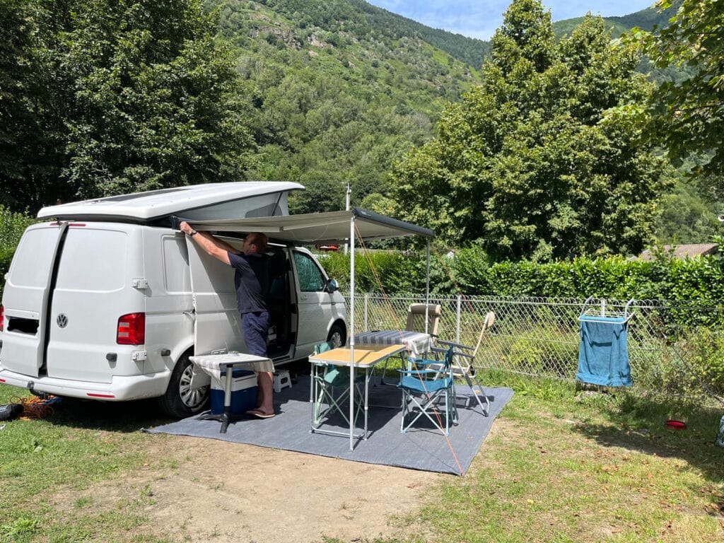 Homme installant auvent de van aménagé au camping