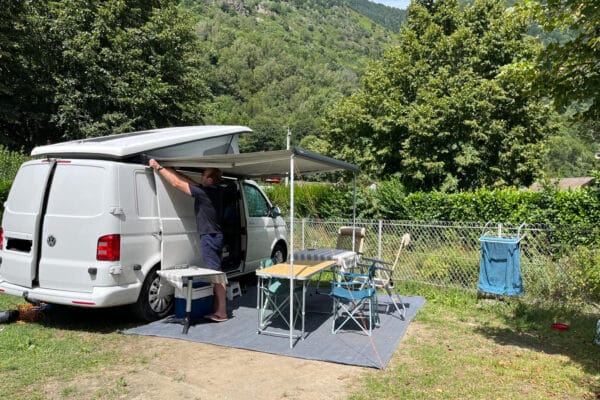 Homme installant auvent de van aménagé au camping