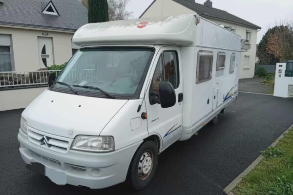 Camping-car blanc stationné dans rue résidentielle