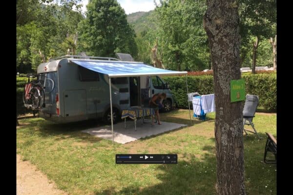 Camping-car installé sur emplacement ombragé en camping