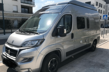 Furgone camperizzato grigio parcheggiato in città