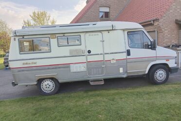 Camper Eriba bianca parcheggiata davanti a una casa in mattoni