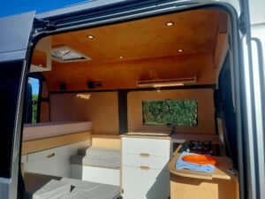 Intérieur aménagé de van avec kitchenette et lit