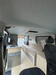 Intérieur aménagé d'un van avec kitchenette et banquette