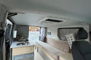 Intérieur aménagé d'un van avec kitchenette et banquette