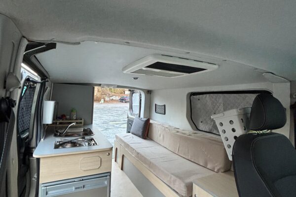 Intérieur aménagé d'un van avec kitchenette et banquette