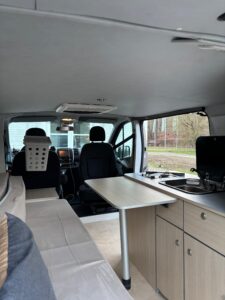Intérieur aménagé d’un van avec kitchenette et banquette