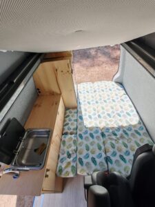 Intérieur van aménagé avec lit et kitchenette bois