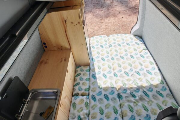 Intérieur van aménagé avec lit et kitchenette bois