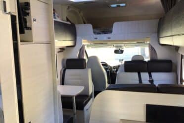 Intérieur moderne de camping-car avec couchage et banquettes