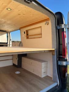 Intérieur de van aménagé avec lit en bois
