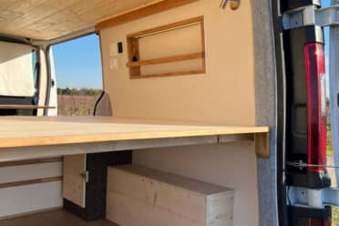 Interno dell'Van camperizzato con letto in legno