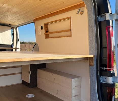 Intérieur de van aménagé avec lit en bois