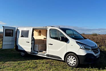 Van camperizzato bianco parcheggiato in campagna