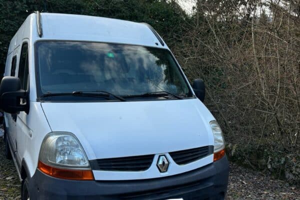 Fourgon blanc Renault stationné près d’arbres en hiver