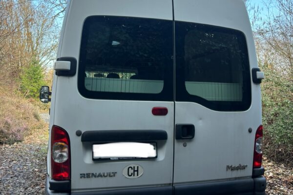 Arrière d’un fourgon Renault blanc en forêt