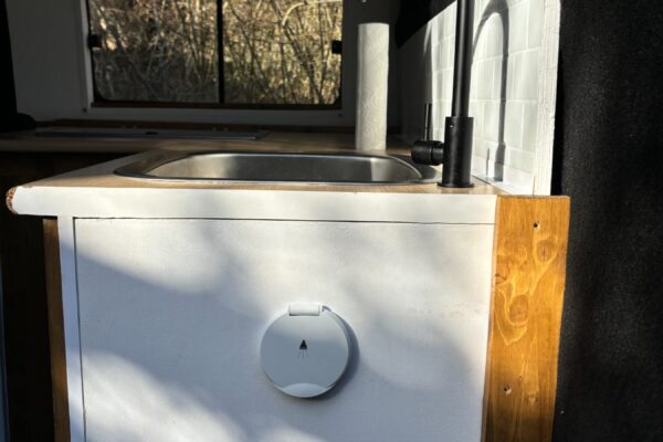 Évier compact avec robinet noir dans van aménagé