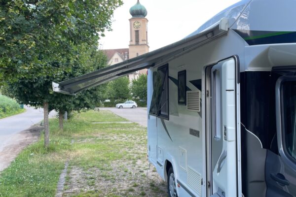 Camping-car stationné près d’une église de village