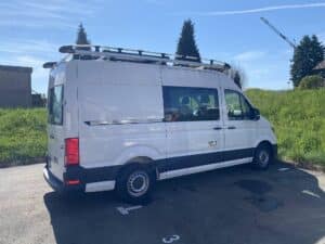 Fourgon blanc utilitaire garé sur parking ensoleillé