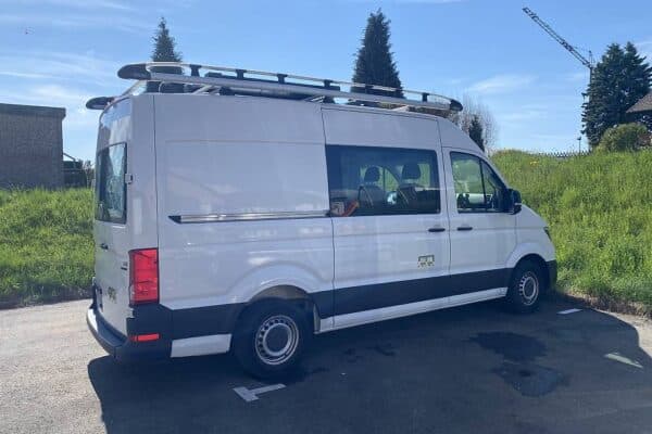 Fourgon blanc utilitaire garé sur parking ensoleillé
