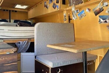 Intérieur aménagé d’un van avec banquette et table