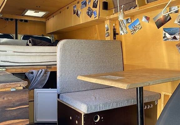 Intérieur aménagé d’un van avec banquette et table