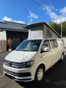 Van Volkswagen blanc avec toit relevable ouvert