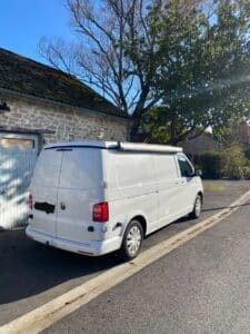 Fourgon Volkswagen blanc stationné près maison en pierre