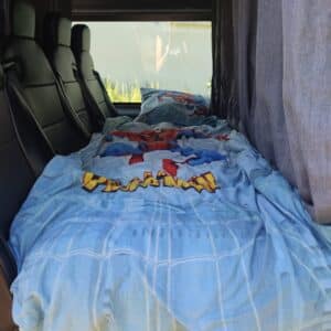 Lit aménagé dans van avec draps Spider-Man
