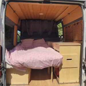 Intérieur de van aménagé avec lit double en bois