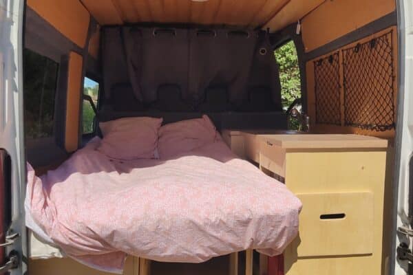 Intérieur de van aménagé avec lit double en bois