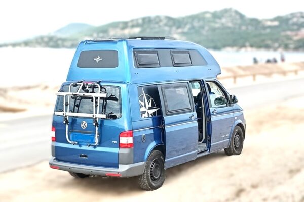 Van aménagé bleu garé sur plage