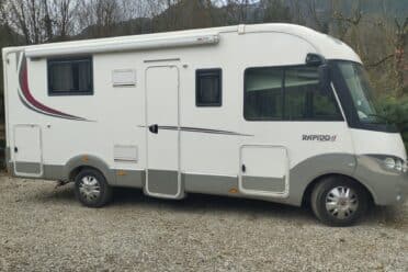 Camper bianco parcheggiato su fondo di ghiaia