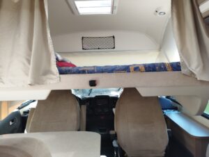 Intérieur camping-car avec lit capucine au-dessus cabine
