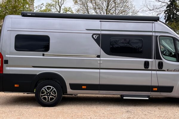 Fourgon aménagé gris stationné en extérieur