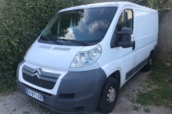 Fourgon utilitaire blanc stationné dans une allée