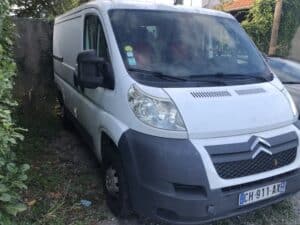 Fourgon utilitaire blanc garé dans une allée